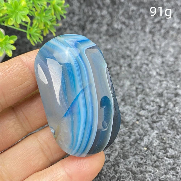 Polished 91g Blue Lace Agate palm stone featuring calming blue bands, perfect for soothing energy and home decor.