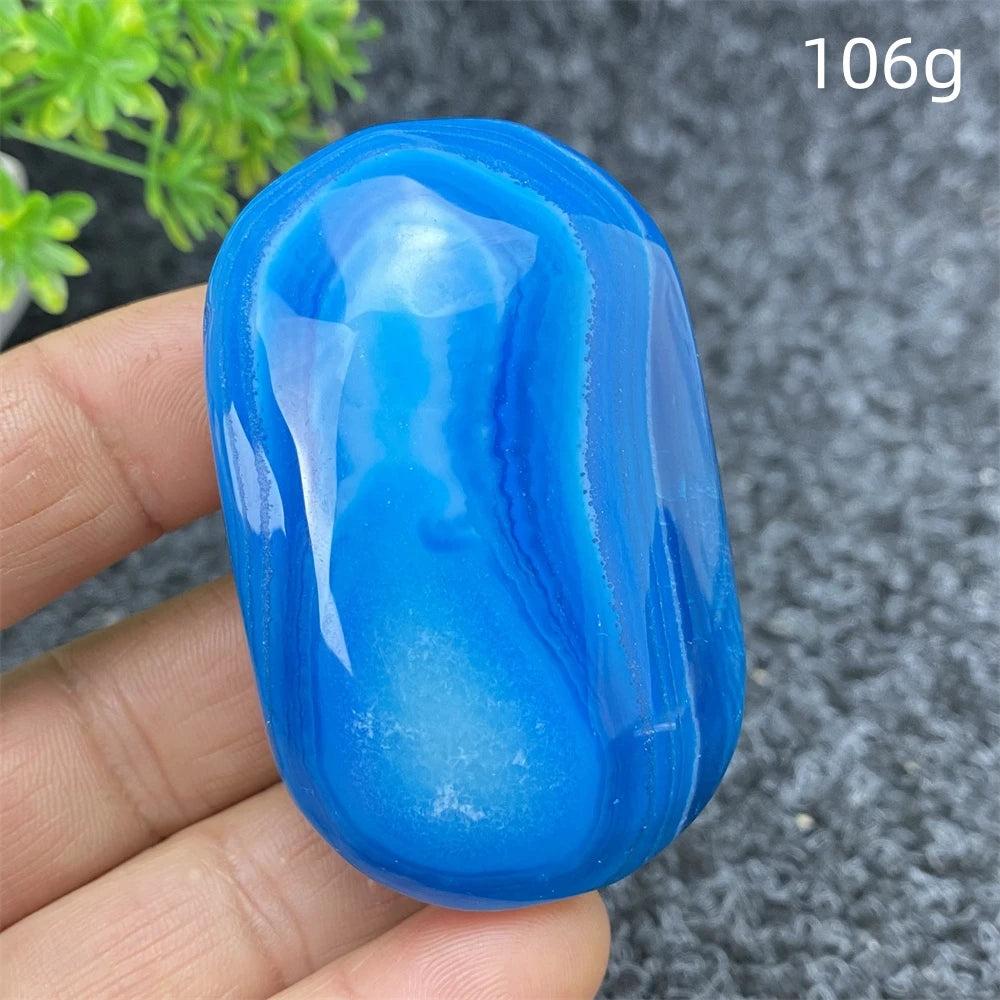 Polished 106g Blue Lace Agate palm stone with calming blue bands, perfect for soothing energy and home decor.