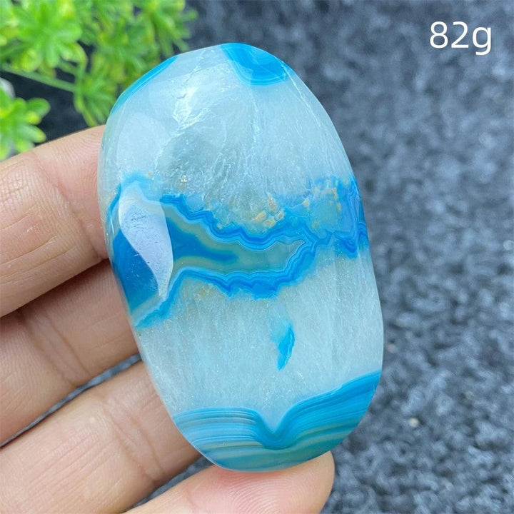 82g polished Blue Lace Agate palm stone featuring calming blue banded patterns, perfect for healing and home decor.