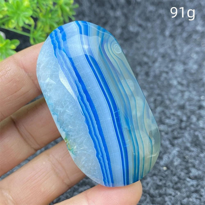 Polished 91g Blue Lace Agate palm stone featuring calming blue banded patterns, perfect for healing and home decor.