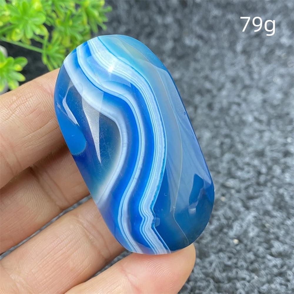 Polished 79g Blue Lace Agate palm stone with calming blue and white banded layers for healing and home decor.