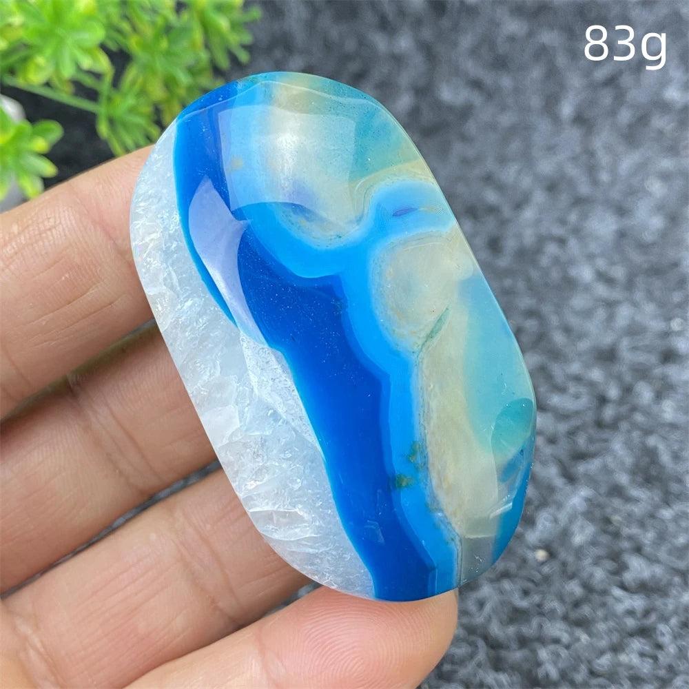 Polished 83g Blue Lace Agate palm stone featuring vibrant blue banding and calming energy for home decor or meditation.