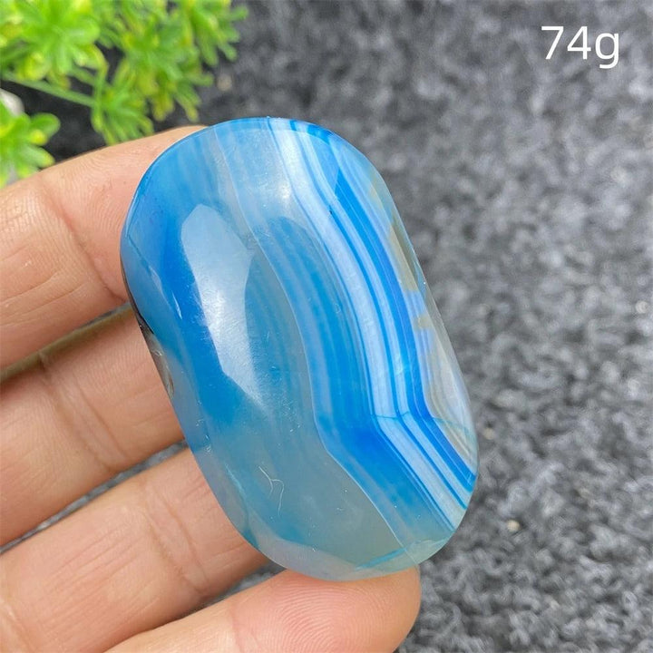 Polished 74g Blue Lace Agate palm stone with calming blue banded patterns, perfect for healing and home decor.