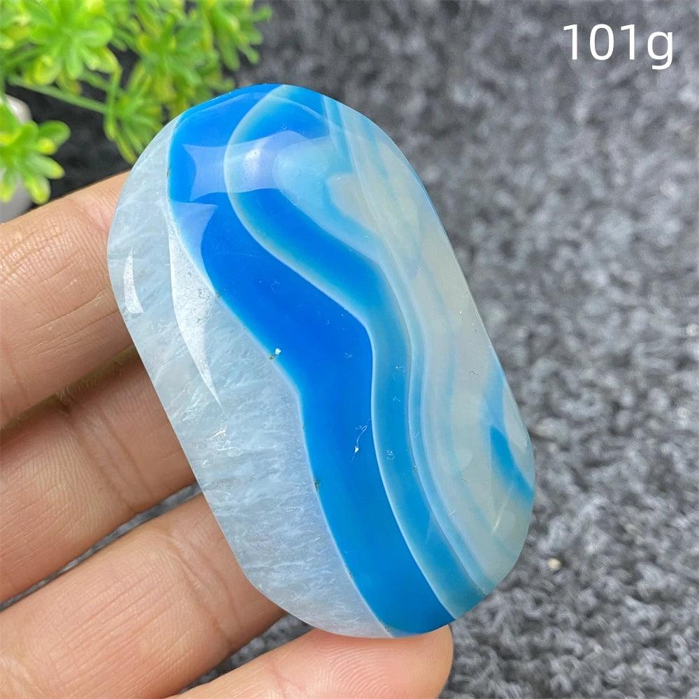 Polished 101g Blue Lace Agate palm stone with calming blue and white banded patterns, perfect for healing and home decor.