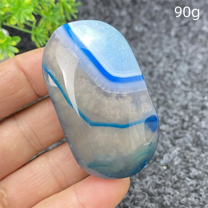 Polished 90g Blue Lace Agate palm stone featuring calming blue banded patterns, perfect for healing and home decor.