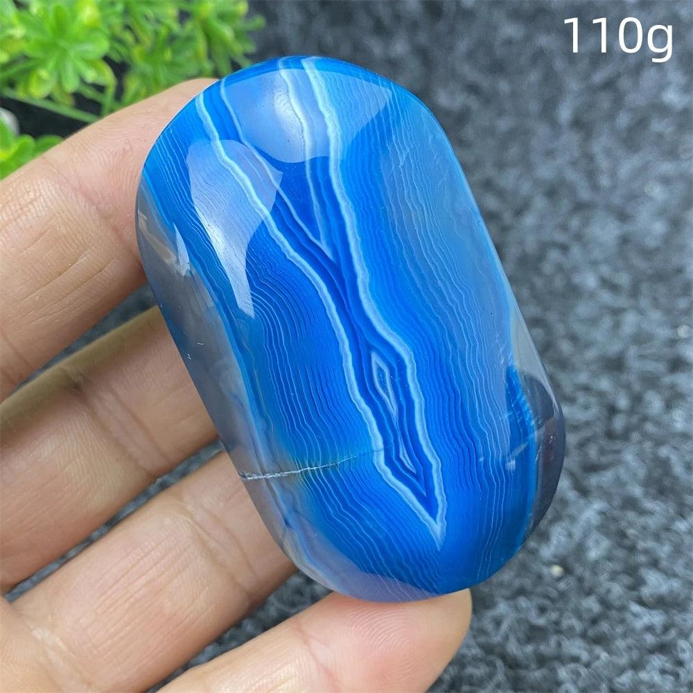 Polished 110g Blue Lace Agate palm stone featuring vibrant blue banded patterns for calming energy and home decor.