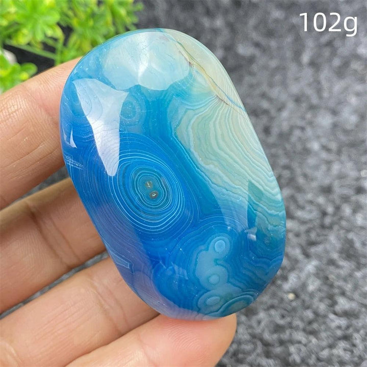 Polished 102g Blue Lace Agate palm stone featuring calming blue banded patterns, perfect for healing and home decor.