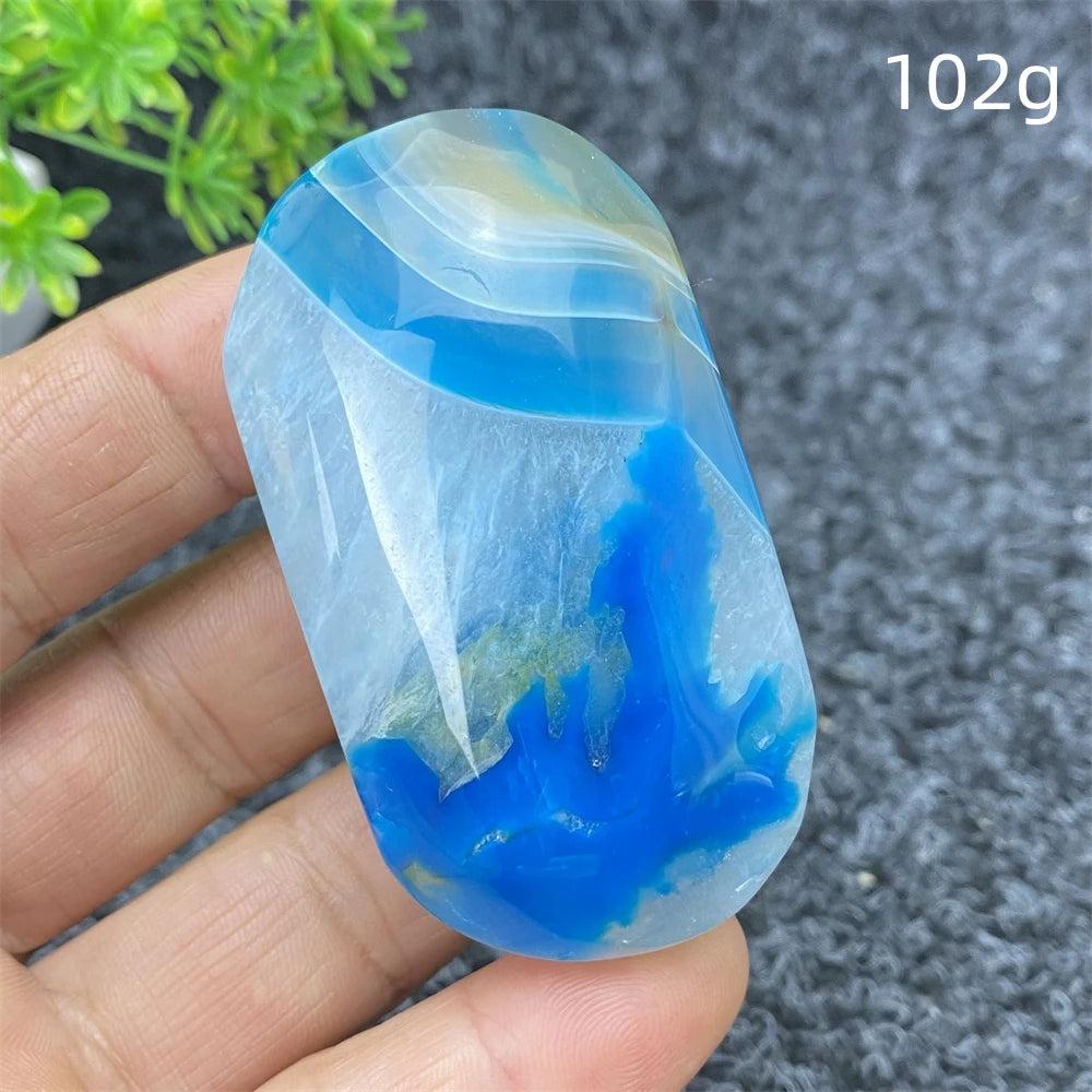 Polished 102g Blue Lace Agate palm stone featuring calming blue swirls and natural crystal patterns for healing decor.