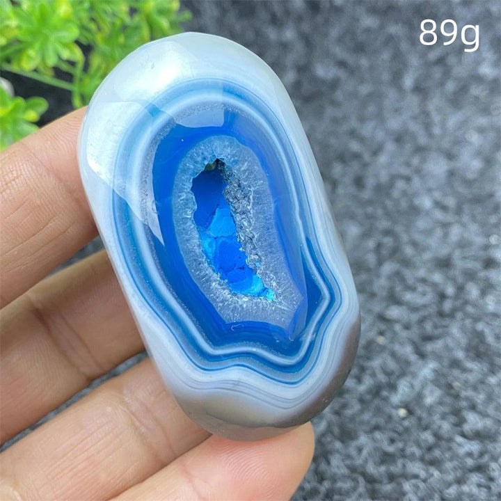 Polished 89g Blue Lace Agate palm stone with a vibrant, sparkling geode center for calming energy and home decor.