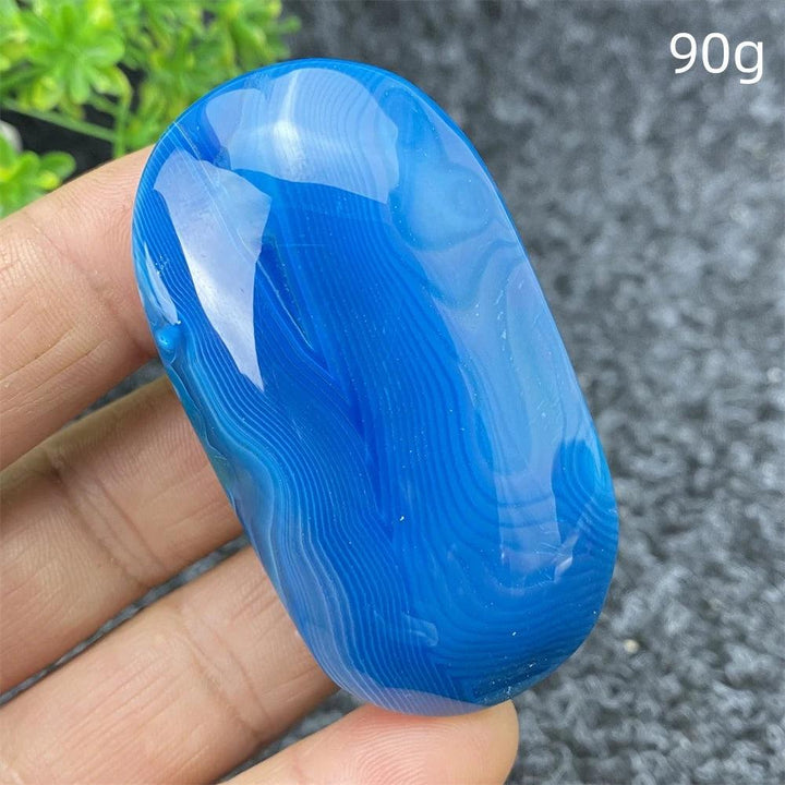 Polished 90g Blue Lace Agate palm stone with calming blue banded patterns, perfect for healing, meditation, and decor.