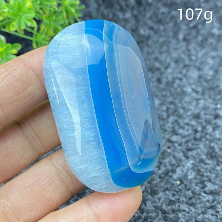 Polished 107g Blue Lace Agate palm stone with calming blue bands, perfect for soothing energy and home decor.