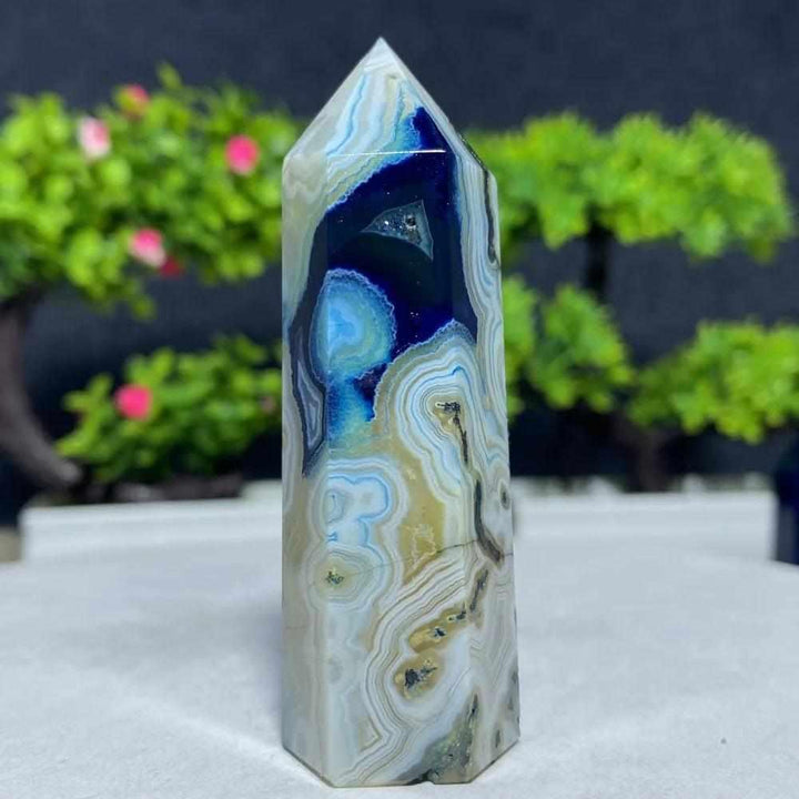 Polished Blue Lace Agate tower featuring calming sky blue and white banded patterns for throat chakra healing and peace.