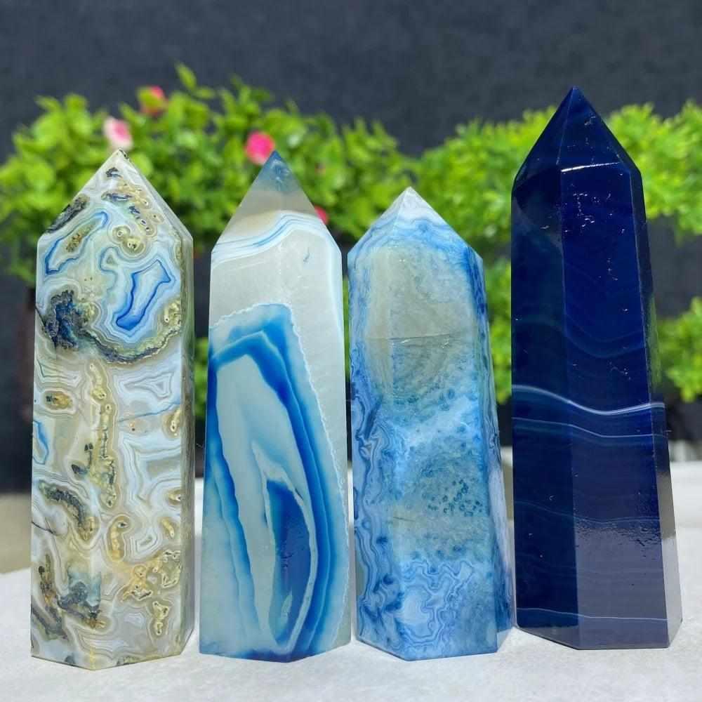 Four polished Blue Lace Agate towers featuring calming sky blue and white banded patterns for throat chakra healing.