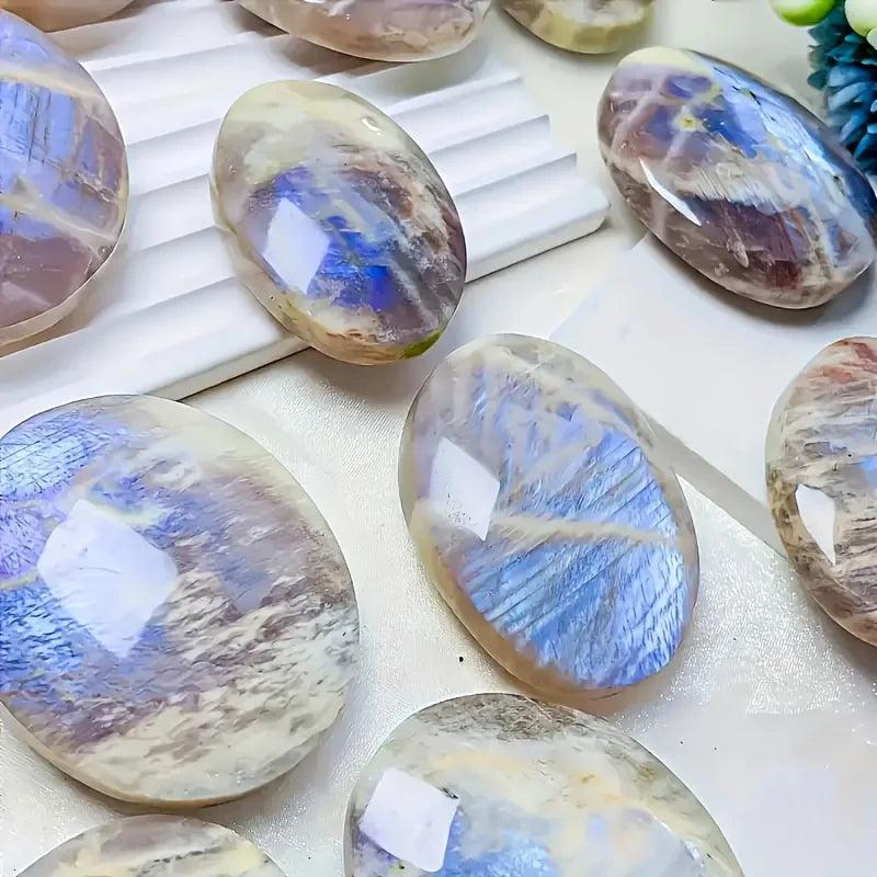 Polished Blue Moonstone oval palm stones with glowing blue adularescence for meditation and chakra healing.