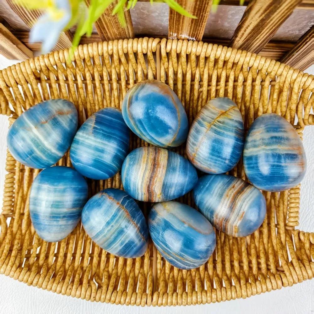 Blue Onyx Crystal Polished Eggs for calm and clarity, with cool blue and brown bands, in a woven basket.