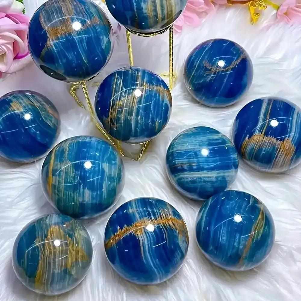 Polished Blue Onyx spheres featuring deep blue bands and golden accents, perfect for Throat and Third Eye chakra healing.