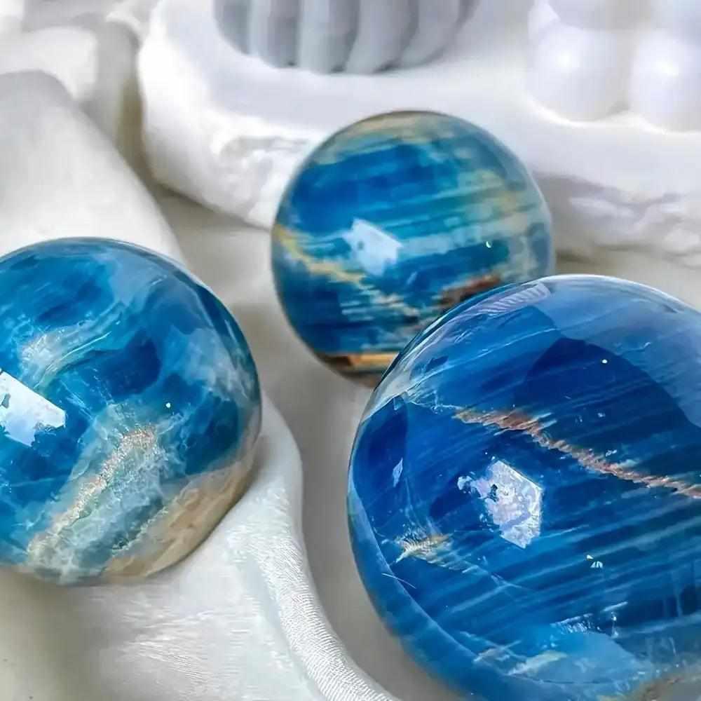 Polished Blue Onyx spheres featuring deep blue layered bands, perfect for Throat and Third Eye chakra meditation.