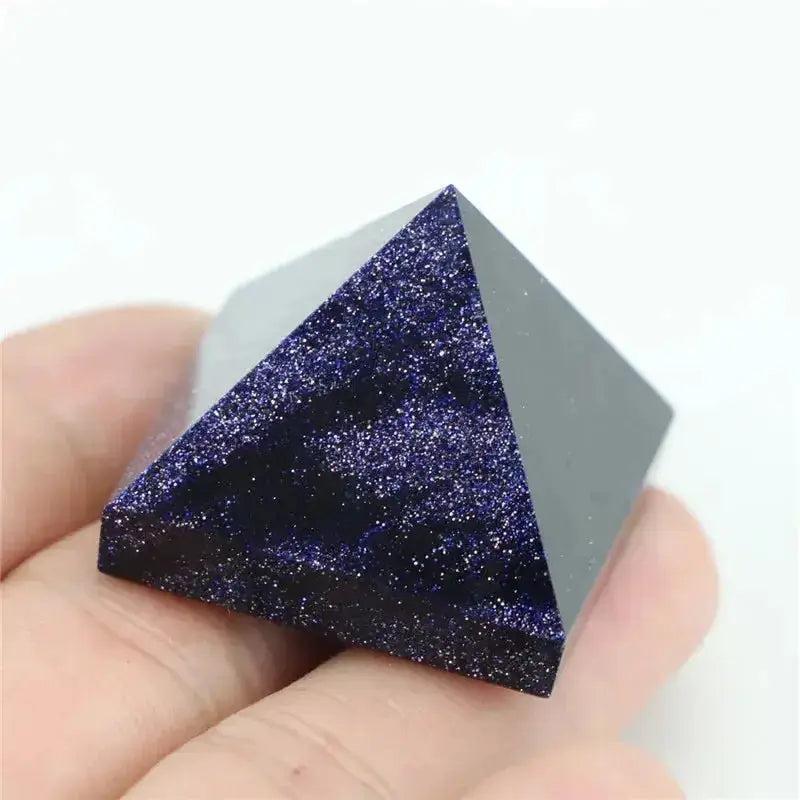 Polished Blue Sandstone crystal pyramid with shimmering gold flecks, held in a hand.