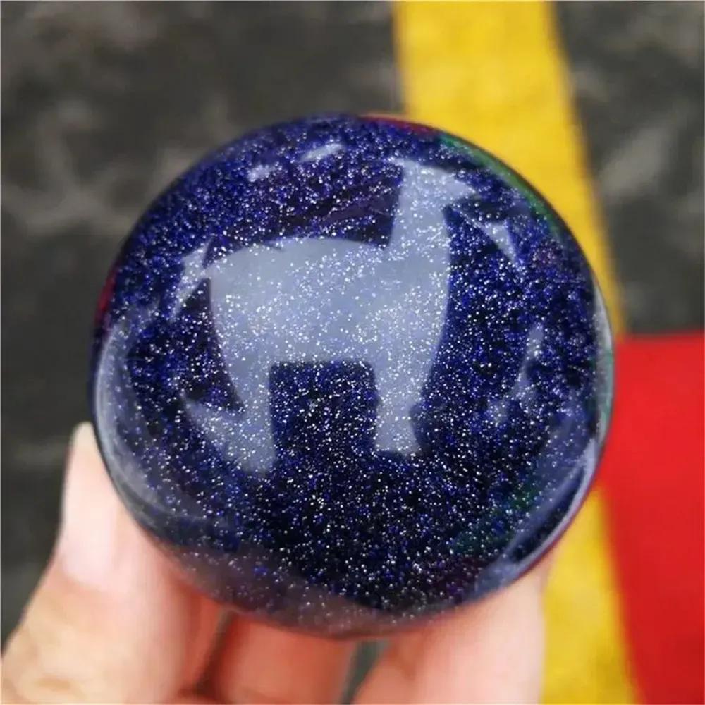 Crystal Destiny's shimmering blue sandstone sphere with golden sparkles and a deer reflection, inspiring ambition.