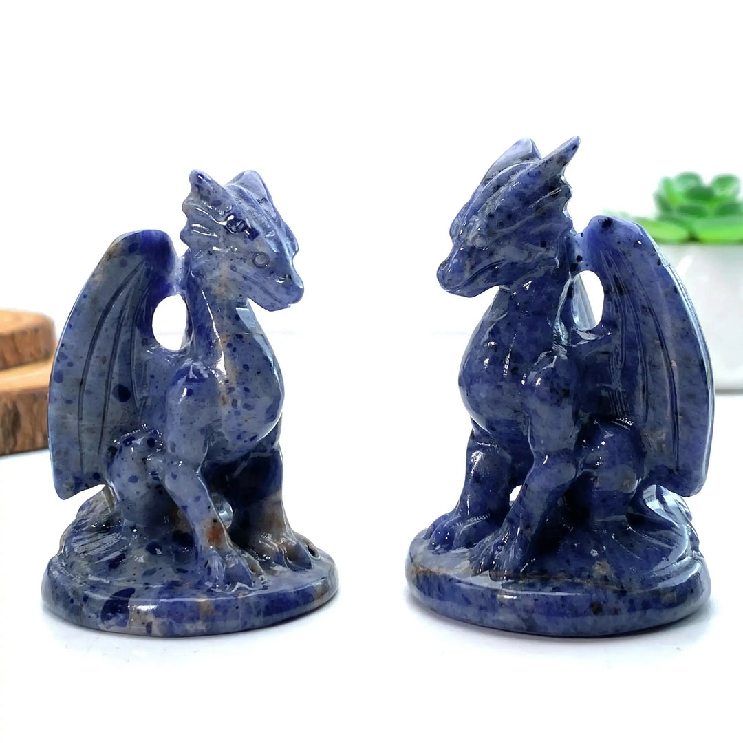 Two polished blue sodalite dragon carvings featuring intricate winged designs, perfect for Throat Chakra meditation.