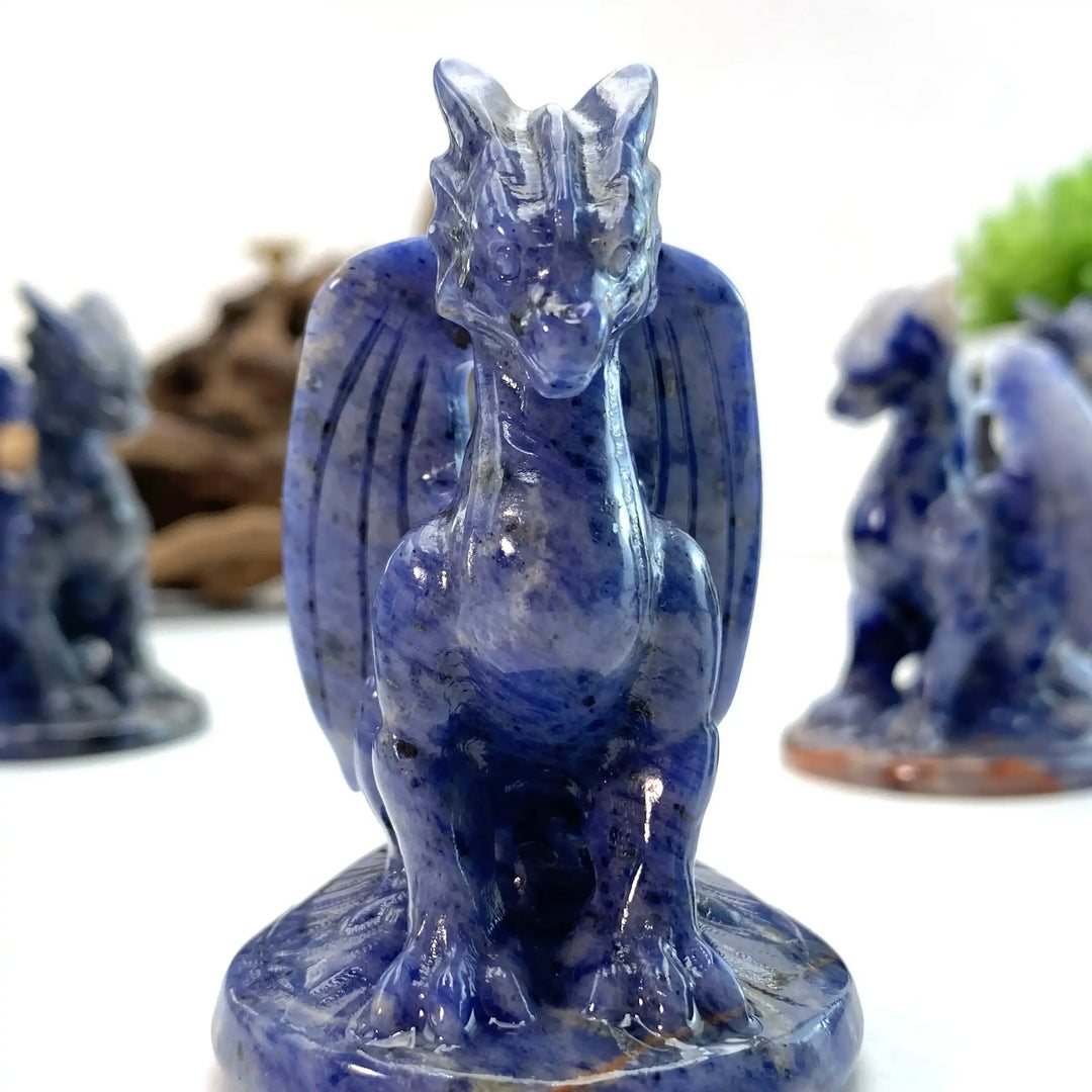 Polished blue sodalite dragon carving with intricate wings and mottling, perfect for Throat Chakra healing and decor.