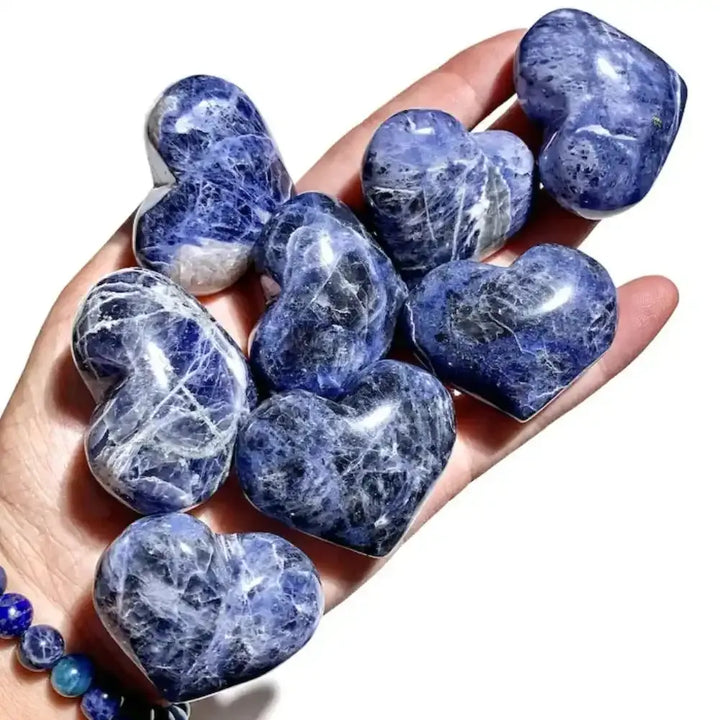 Polished blue sodalite hearts with white marbling, perfect for Throat Chakra healing and crystal collections.