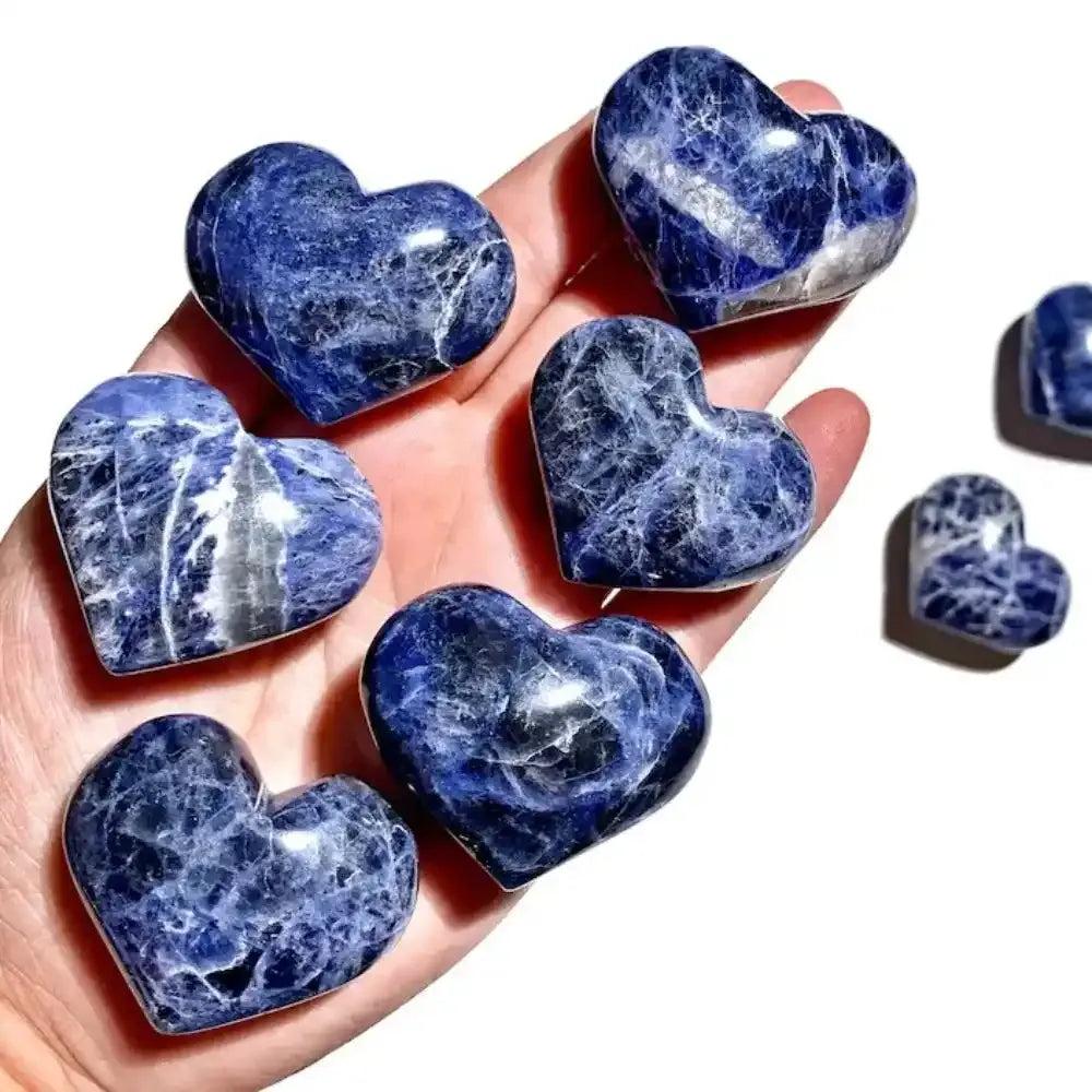 Polished blue sodalite heart crystals featuring unique white patterns, perfect for Throat Chakra healing and meditation.