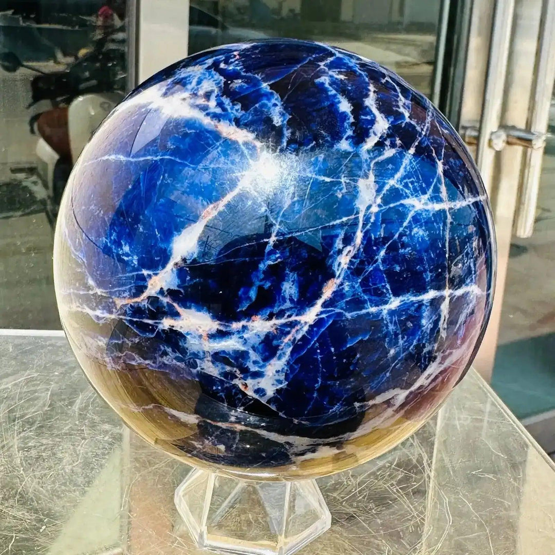 Polished Blue Sodalite sphere featuring deep blue tones and striking white veins, perfect for Throat Chakra healing.