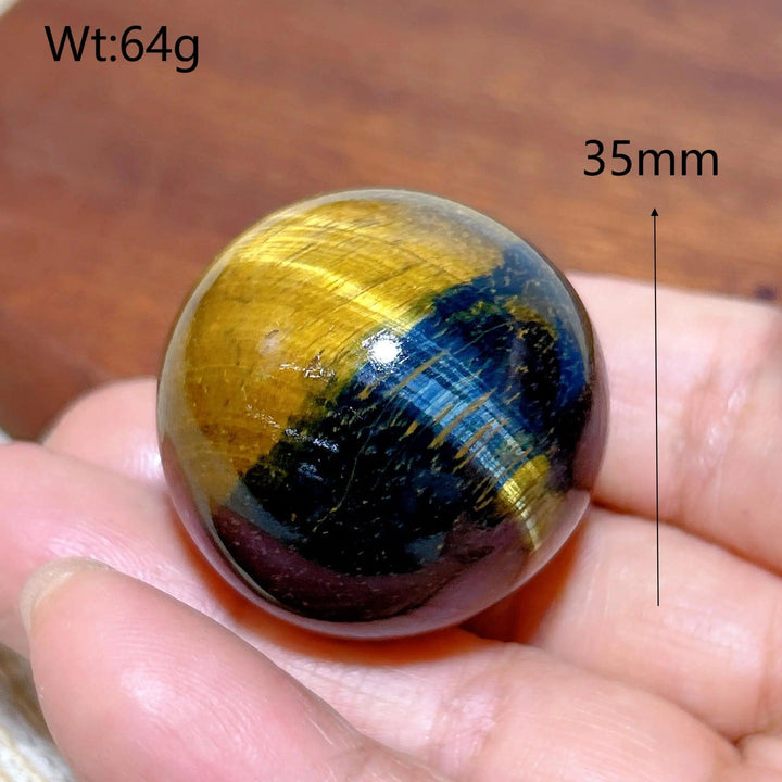 35mm Blue and Yellow Tiger Eye crystal sphere, a polished healing stone ornament with flashy, natural energy patterns.