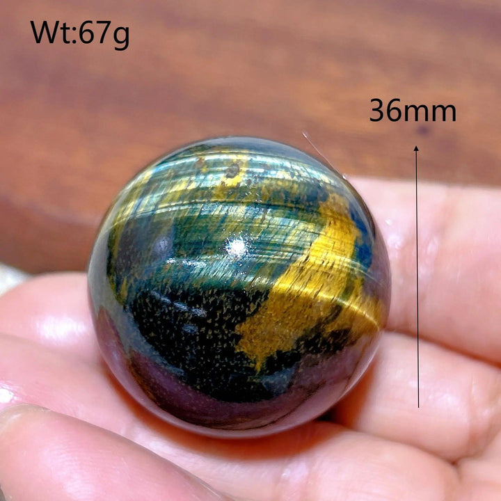 36mm Blue and Yellow Tiger Eye crystal sphere, a polished healing stone ornament with flashy, natural energy patterns.