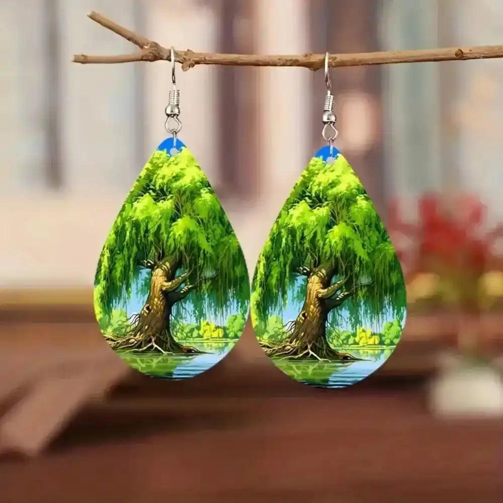 Boho wooden water drop earrings with a vibrant green weeping willow tree design, hanging from a branch.