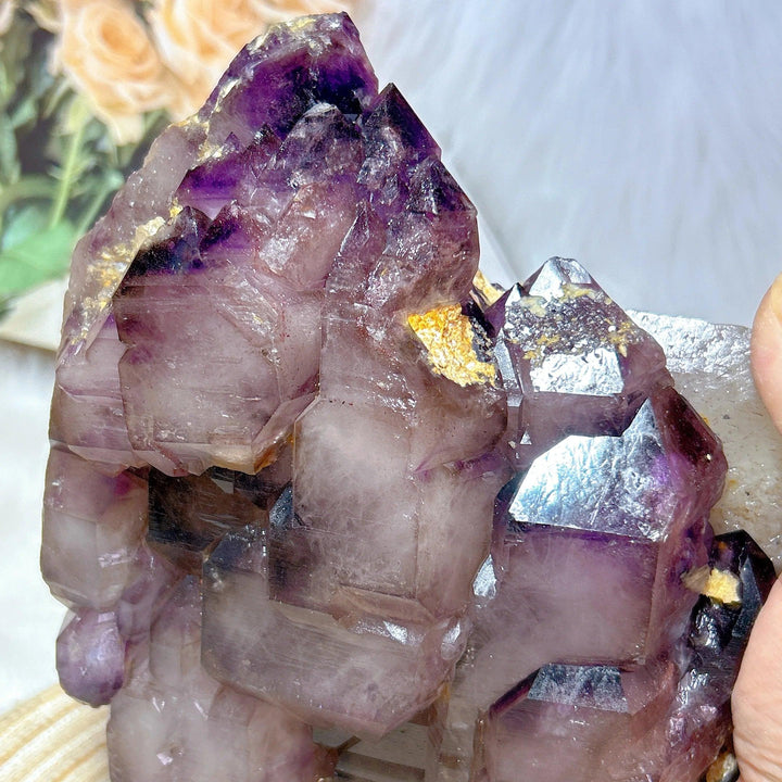 Rare Brazilian amethyst skeletal elestial cluster with deep violet points and raw, layered geometric formations.