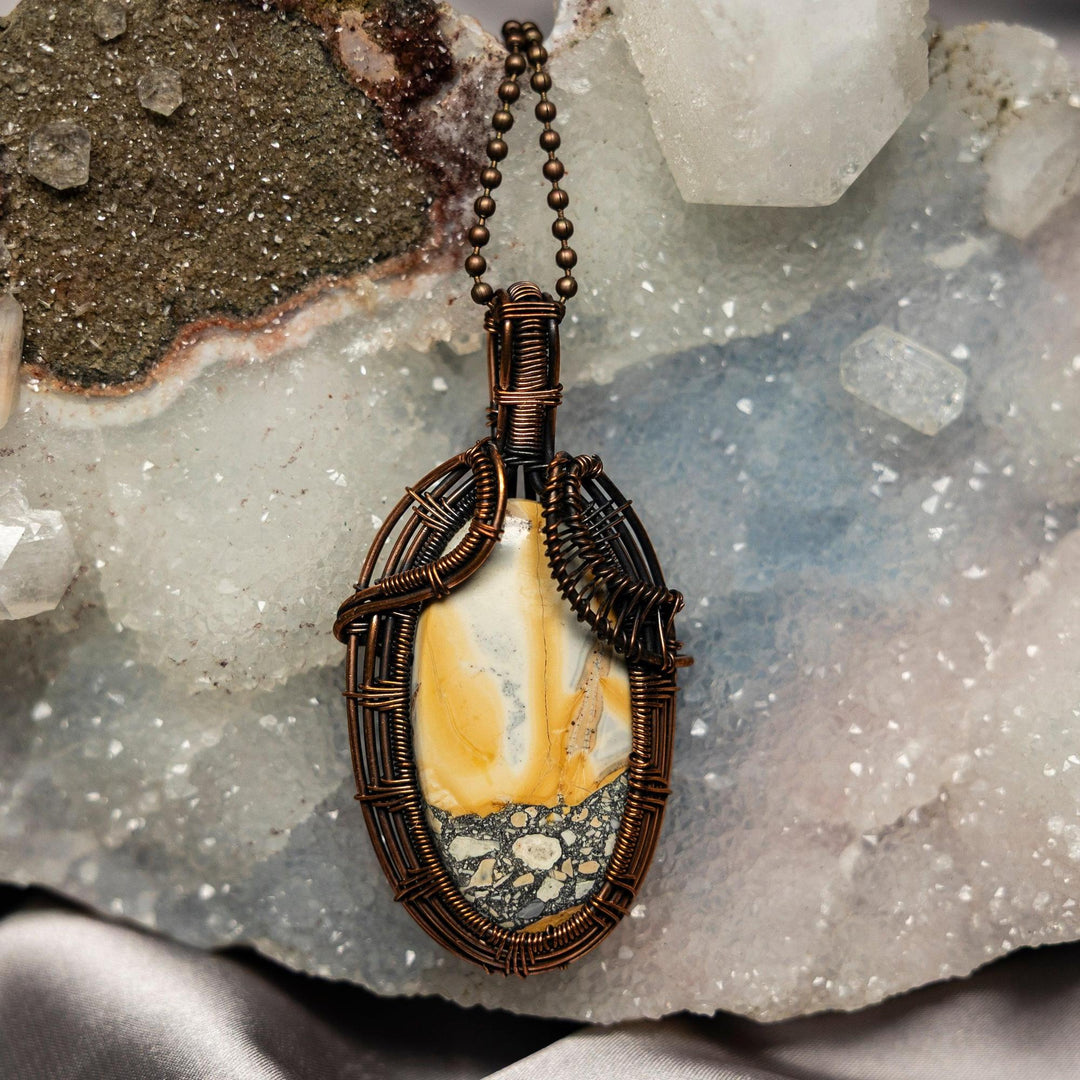 Brecciated Jasper Wire Wrap Pendant #1: Oval stone with red, brown, and gray fragments, wrapped in copper wire.
