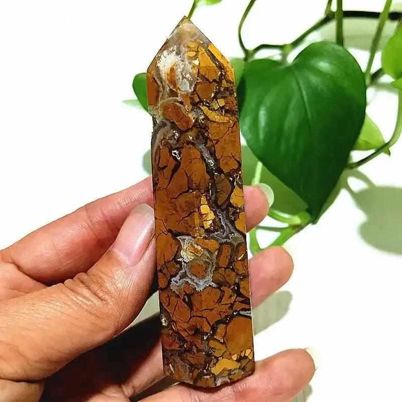 Polished Brecciated Jasper tower with red and brown mosaic patterns for grounding, held in hand for scale.