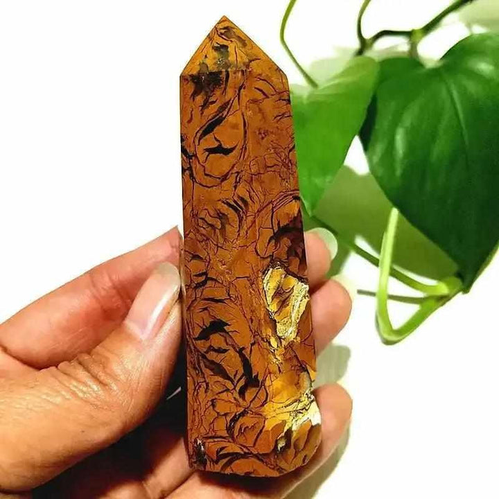 Polished Brecciated Jasper tower with red and brown mosaic patterns for grounding, held in hand for scale.