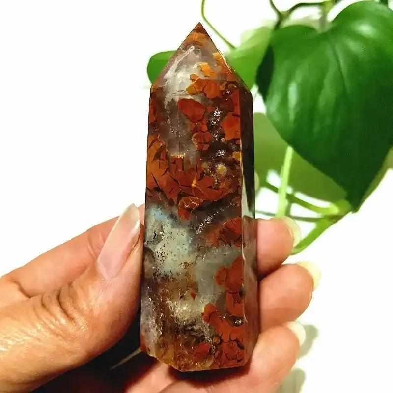 Polished Brecciated Jasper tower with red and brown mosaic patterns for grounding, held in hand for scale.