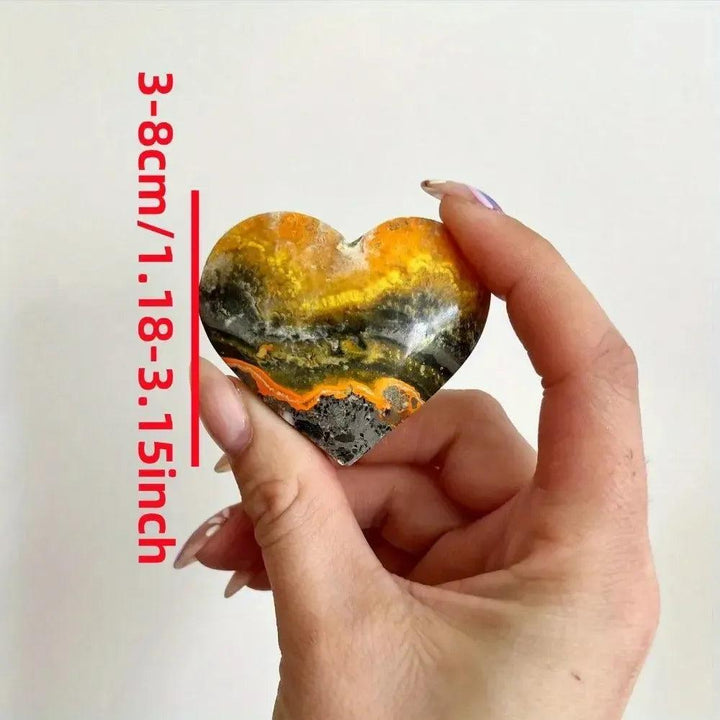 Bumble Bee Jasper Crystal Heart: Vibrant yellow, orange, and black banded heart-shaped crystal, held in hand.