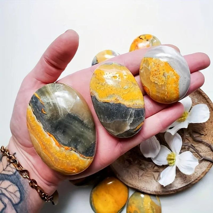 Polished Bumblebee Jasper Beehive Crystal Palm stones with vibrant yellow, grey, and black bands.