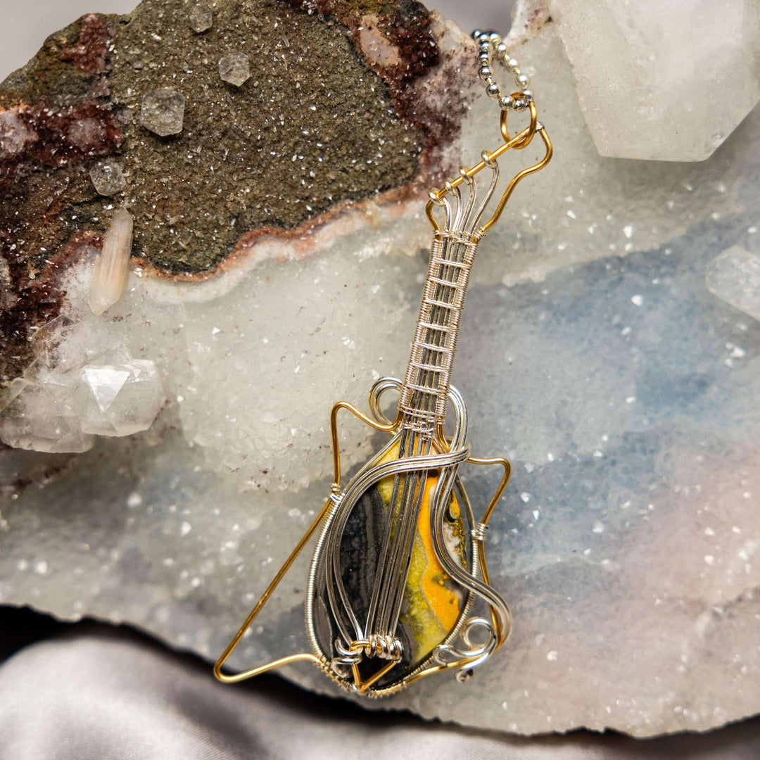 Bumblebee Jasper guitar pendant by Crystal Destiny, featuring vibrant yellow, black, and orange stone with copper wire wrap.