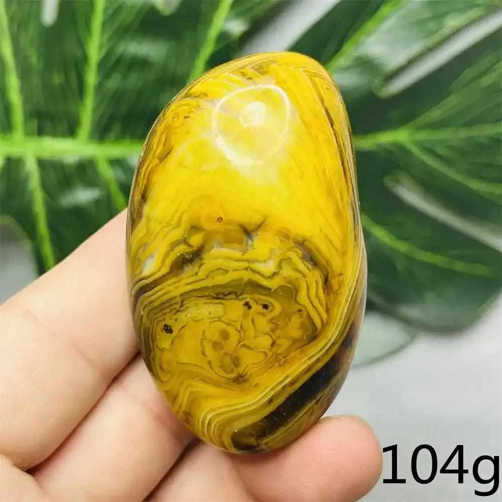 Smooth Bumblebee Jasper palm stone with vibrant yellow and black stripes for optimism and Solar Plexus chakra energy.
