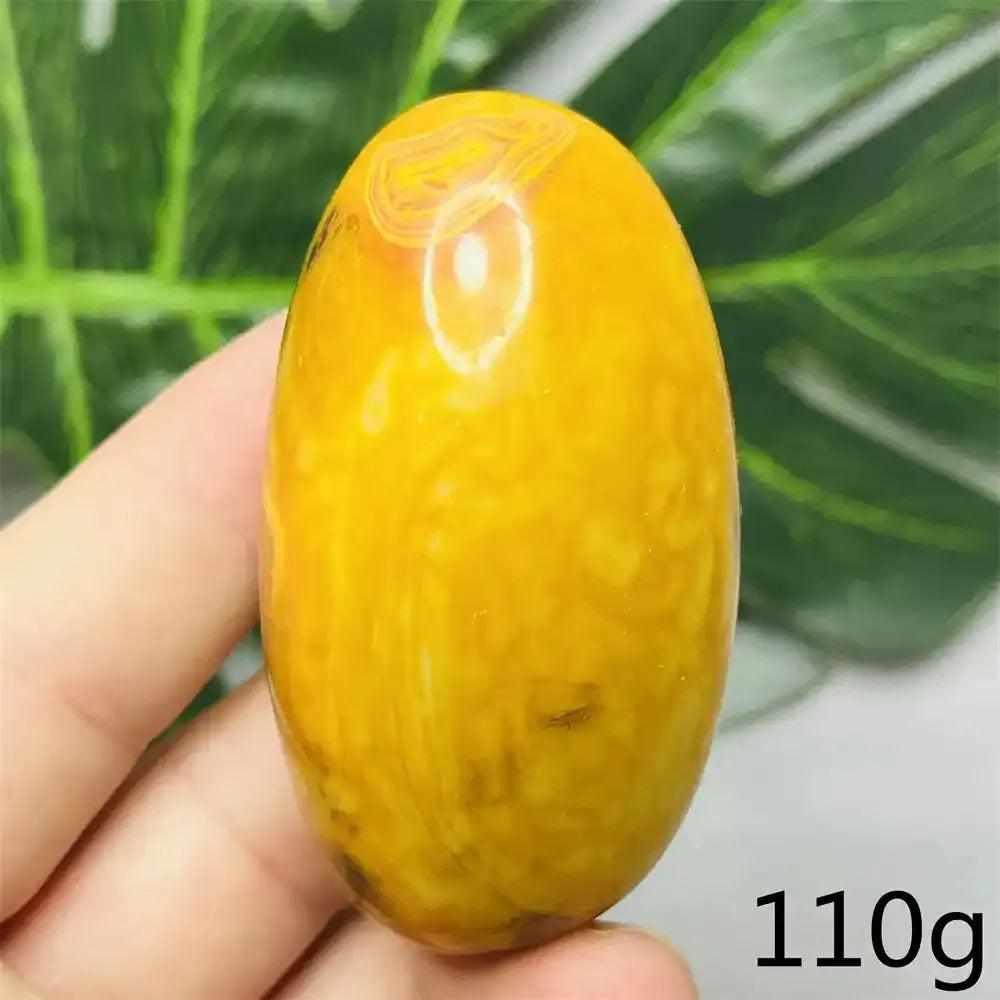 Smooth, hand-polished Bumblebee Jasper palm stone featuring vibrant yellow and orange stripes for energy and optimism.
