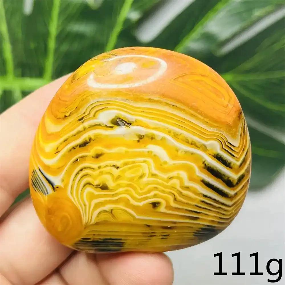 Smooth 111g Bumblebee Jasper palm stone featuring vibrant yellow, orange, and black stripes for optimism and motivation.