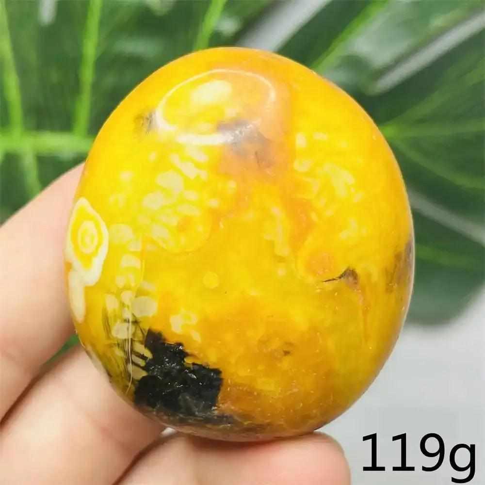 Smooth, hand-polished Bumblebee Jasper palm stone featuring vibrant yellow, orange, and black stripes for solar energy.