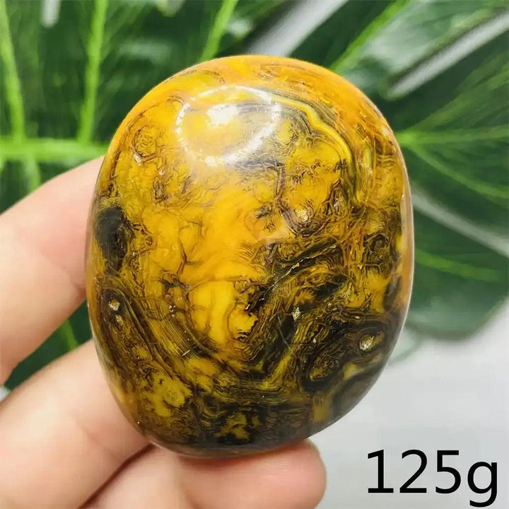 Smooth Bumblebee Jasper palm stone with vibrant yellow, orange, and black stripes for optimism and solar plexus energy.