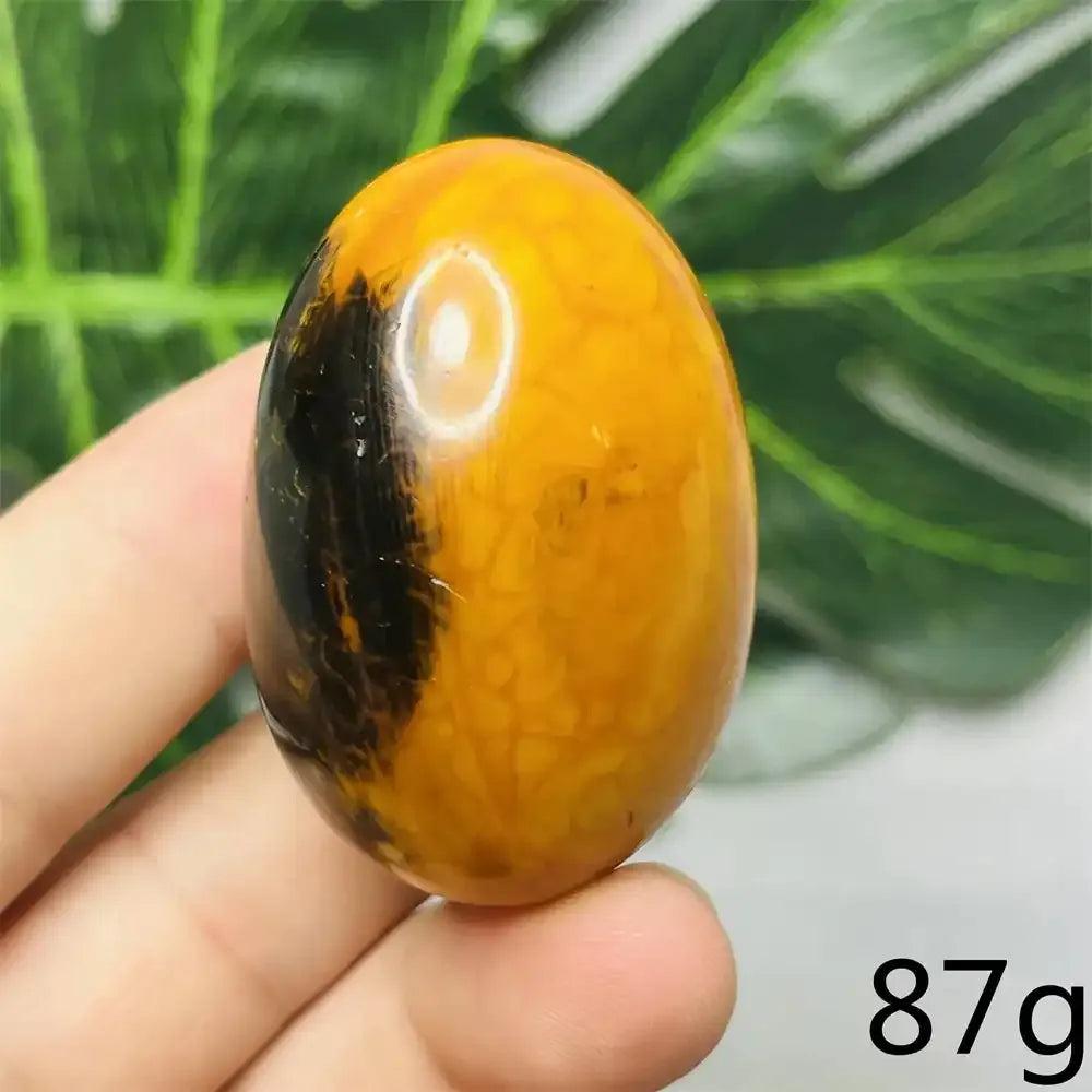 Smooth Bumblebee Jasper palm stone featuring vibrant yellow and black stripes for optimism and Solar Plexus chakra healing.