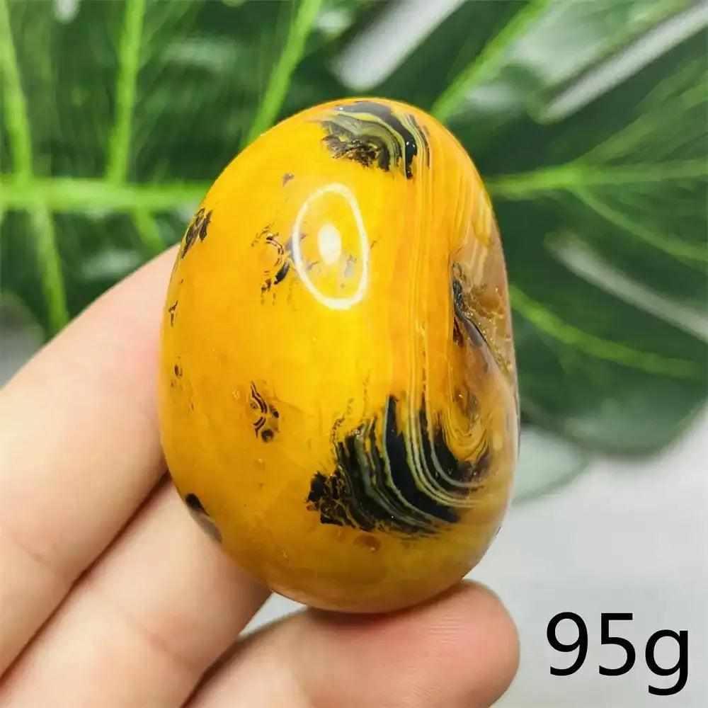 Smooth, hand-polished Bumblebee Jasper palm stone featuring vibrant yellow, orange, and black stripes for solar energy.