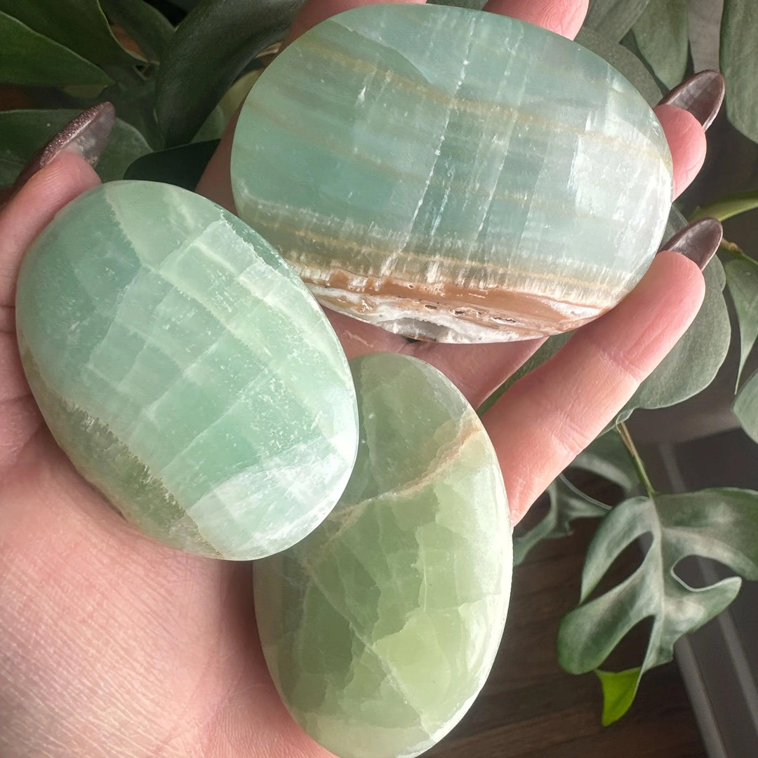 Polished Caribbean Calcite palm stones in ocean blue and tan, perfect for calming anxiety.