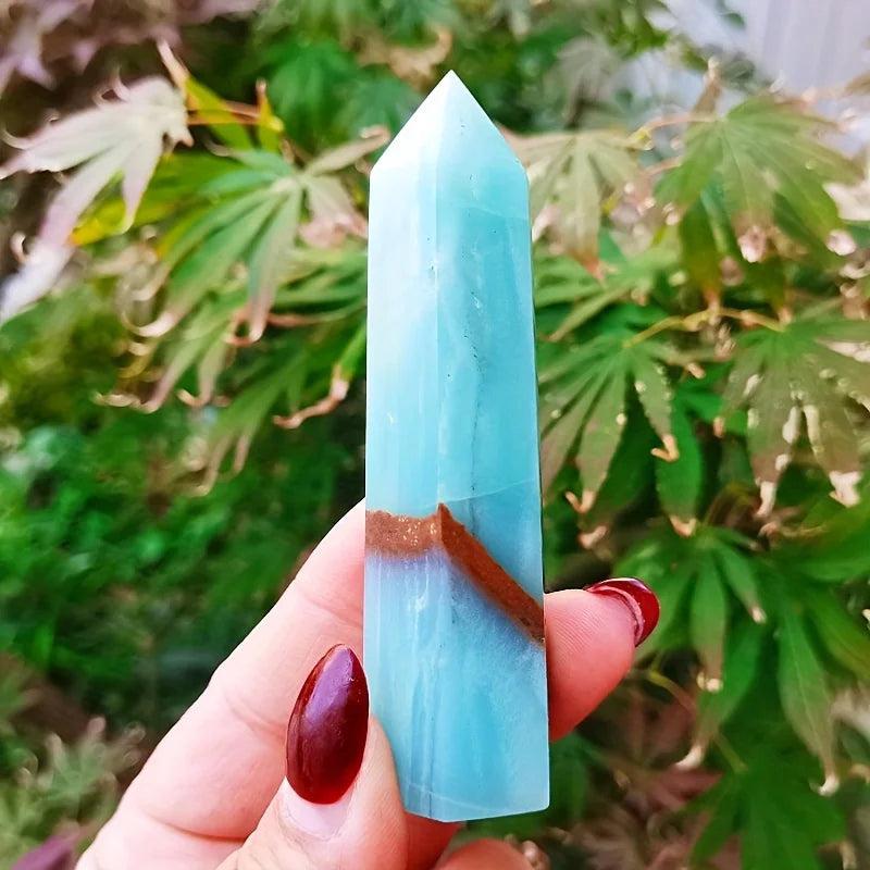 Polished sky blue quartz column crystal point with natural brown banding for healing and decor.
