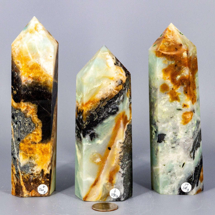 Three Caribbean Calcite Tower XXL crystals, showcasing soft ocean blue, creamy white, and warm brown banding.