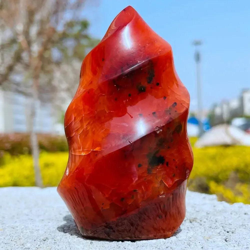 Vibrant Carnelian Crystal Flame, a hand-carved, polished fiery orange-red stone for vitality and creativity.